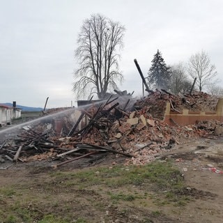 Letzte Löscharbeiten nach einem Gebäudebrand. Das Haus wurde vollständig zerstört.