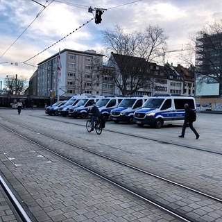 Viele Mannschaftswagen der Polizei stehen am Platz der alten Synagoge und vor dem Stadttheater in Freiburg.