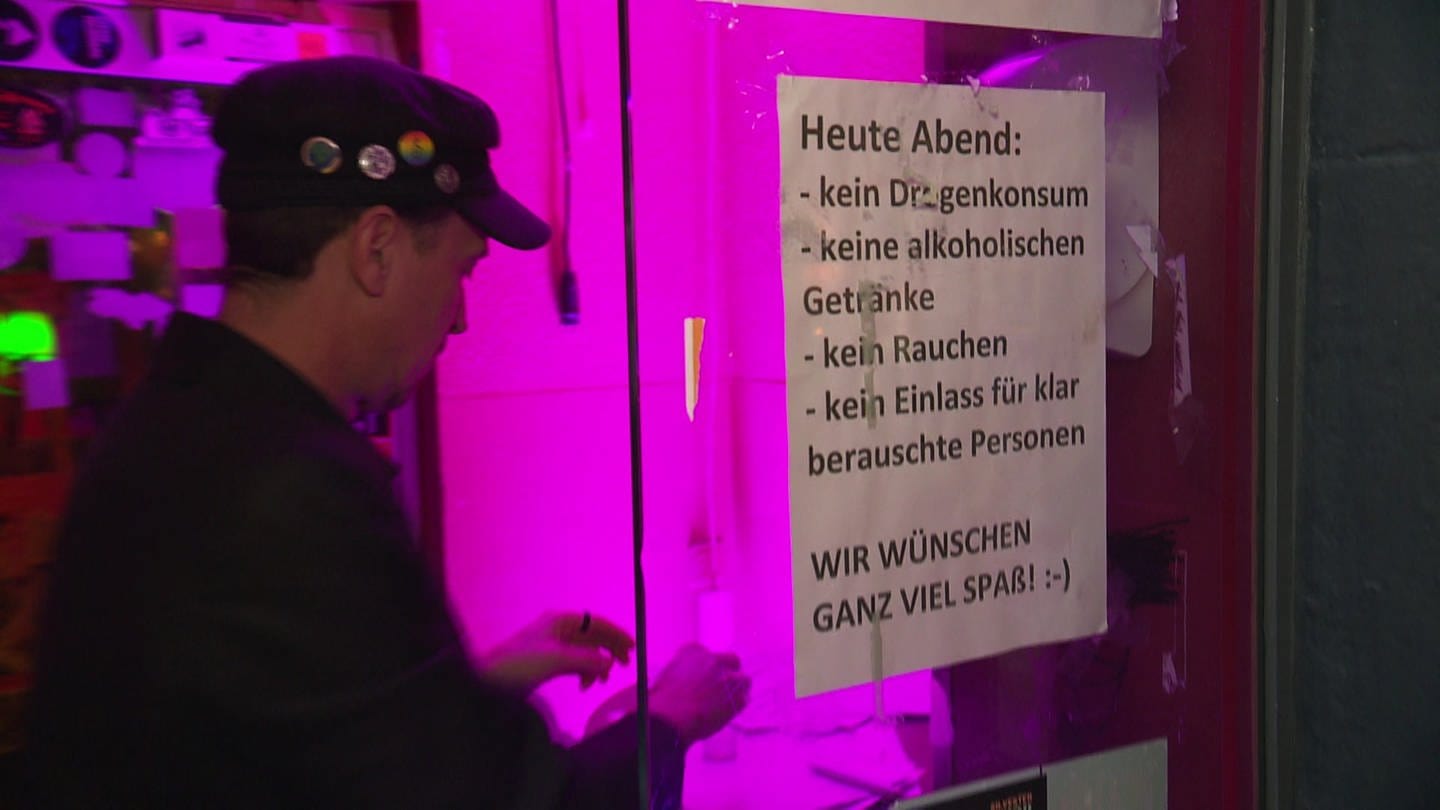 DJ Hurricane hängt das Info-Plakat am Eingang des Clubs auf