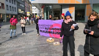 Frauen mit einem Transparent "Bundesweiter Streik Autonomer Frauenhäuser"