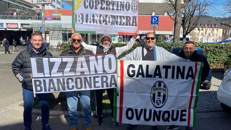 Fans von Juventus Turin halten Transparente hoch. Sie treffen sich vor dem Spiel gegen den SC Freiburg in der Freiburger Innenstadt.