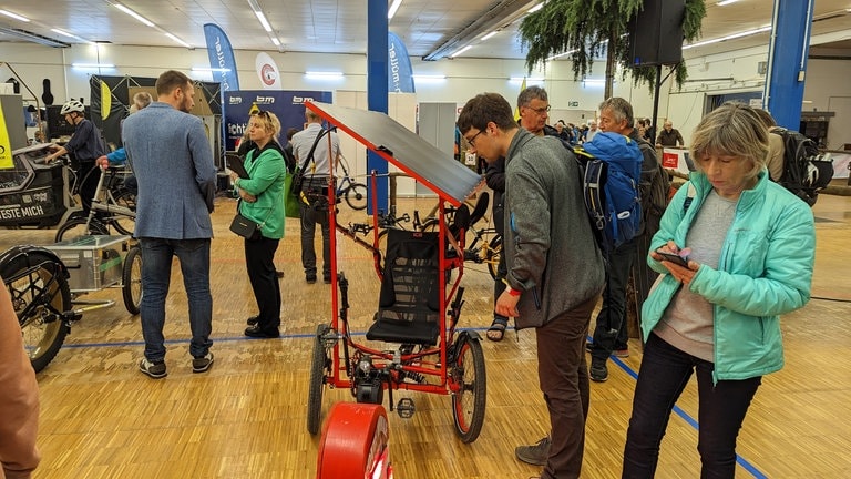 Mann schaut auf Solardach eines besonderen Fahrrads