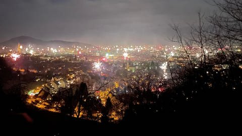 Feuerwerk glitzert über dem erleuchteten Freiburg.