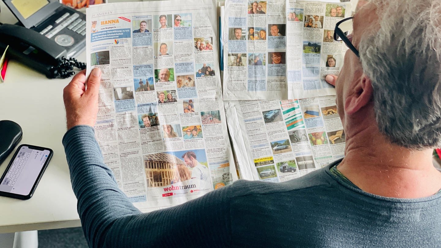 Mann schaut in Zeitung