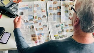 Mann schaut in Zeitung
