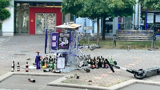 Zwei Einkaufswagen liegen umgekippt auf dem Lederleplatz, umgeben von leeren Flaschen und Müll.