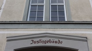 Graues Gebäude mit weißen Fensterrahmen.