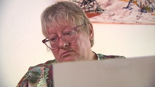 Birgit Reuner blättert in ihren Unterlagen zur neuen Brille.