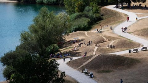 Menschen befinden sich am Ufer des Flückiger Sees