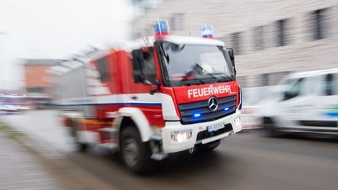 Ein Fahrzeug der Feuerwehr fährt durch eine Stadt (Symbolbild).