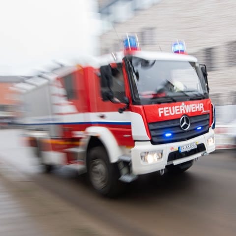 Ein Fahrzeug der Feuerwehr fährt durch eine Stadt (Symbolbild).