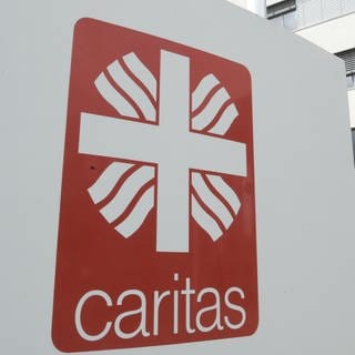 Ein Gebäude von der Caritas in Freiburg mit dem Logo im Vordergrund.