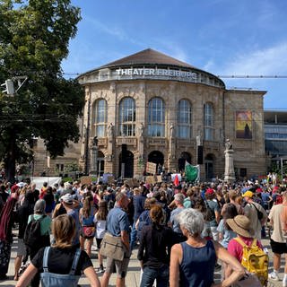 Zahlreiche junge Leute sind auf dem Platz der Alten Synagoge und vor dem Freiburger Stadttheater zu sehen.