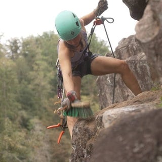 Annika Carstens säubert den Kletterfelsen bei Albbruck am Hochrhein