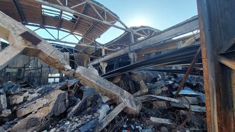 In einer eingestürzten Lagerhalle liegt Schutt auf dem Boden.