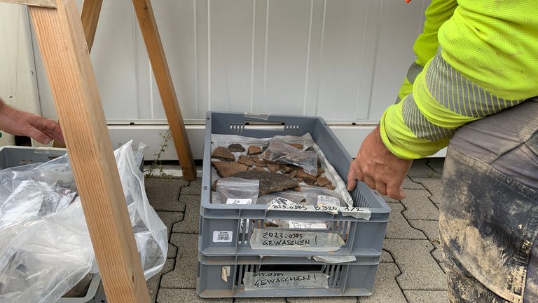 In einem Korb liegen Ton-Scherben, die auf der Baustelle gefunden wurden.