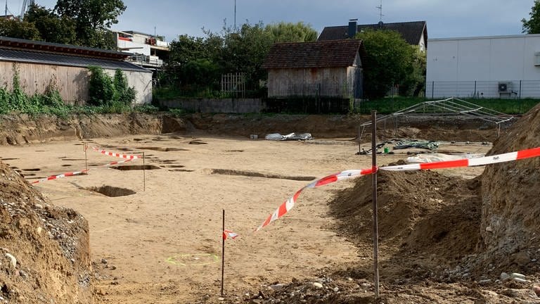 Auf der Baustelle in Endingen sind Löcher von den Grabungen im Boden zu sehen. Am Rand sind Absperrbänder zu sehen.