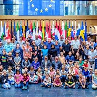 Kinder und Erwachsene posieren für ein Foto im Europäischen Parlament.