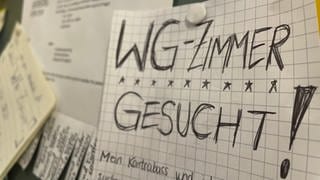 Eine Anzeige WG-Zimmer gesucht hängt an einer Pinnwand in der Uni Freiburg.