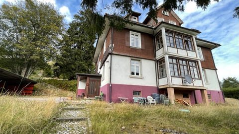 Ein Ferienhaus am Feldberg mit wild bewachsenem Garten im Vordergrund.