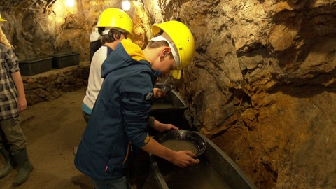 Kind schürft Edelsteine im Bergwerk