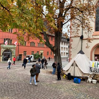 Aktivisten des Freiburger Klimacamps haben mit dem Abbau ihrer Zelte auf dem rathausplatz begonnen. Das Verwaltungsgericht hatte entschieden, dass das Klimacamp für den Weihnachtsmarkt weichen muss. 