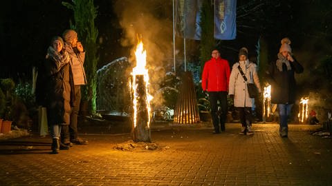 Weihnachtsmarkt in Rümmingen: Menschen um ein brennende Stück Holz