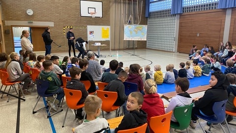 Schülerinnen und Schüler der Markgrafenschule in Freiburg-Tiengen sprechen mit Tobias Adler über den Krieg in der Ukraine. 