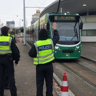 Beamte stehen an einer grünen Tram