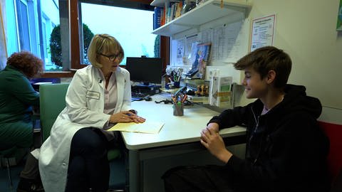 Ärztin Karin Storm van`s Gravesande im Gespräch mit einem jungen Patienten.