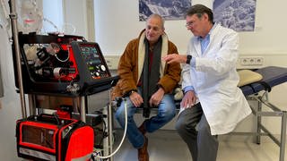 Herzspezialist Friedhelm Beyersdorf (rechts) erklärt Peter Kunzelmann (links) die neue Herz-Lungen-Maschine der Uniklinkik Freiburg