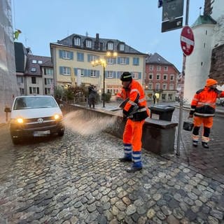 Mitarbeiter der Stadtreinigung streuen das vereiste Pflaster in der Freiburger Innenstadt
