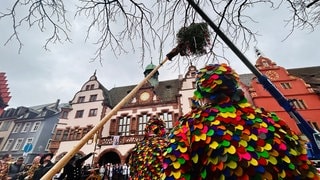 Mann im Häs steht vor dem Narrenbaum in Freiburg