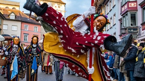 Ein Federahannes springt während des Narrensprungs vor dem Schwarzen Tor