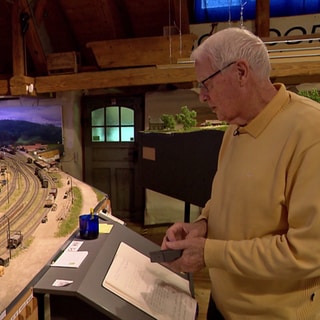 Dieter Bertelsmann blickt auf sein Modell vom Bahnhof Freiburg-Littenweiler.