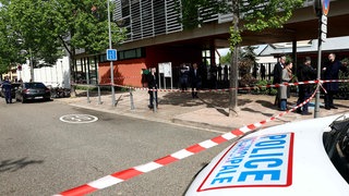 Die Polizei untersucht die Umgebung einer Schule, nachdem zwei Grundschülerinnen bei einem Messerangriff vor der Schule leicht verletzt worden waren.