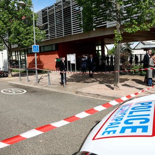 Die Polizei untersucht die Umgebung einer Schule, nachdem zwei Grundschülerinnen bei einem Messerangriff vor der Schule leicht verletzt worden waren.