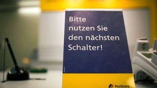 Auf dem Land sind Postfilialen knapp - Postschalter mit Schild: Bitte nutzen Sie den nächsten Schalter