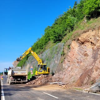 Ein Bagger räumt die letzten Felsbrocken von der Bundesstraße 294.