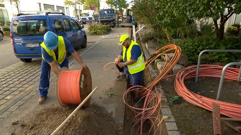 Baurbeiter verlegen rote Kabel  