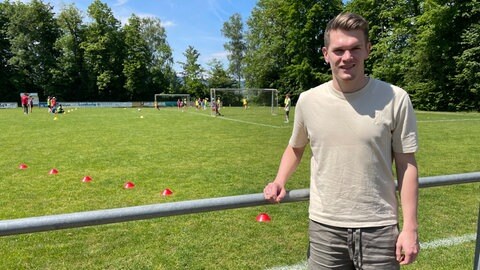 Matthias Ginter steht vor dem Fußballplatz des SC March während des Inklusionsfußballcamps.