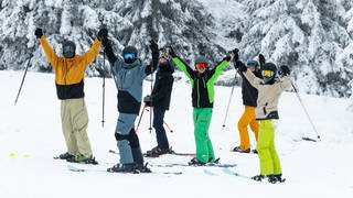 Skifahrerinnen und Skifahrer auf dem Feldberg freuen sich auf der Piste. 