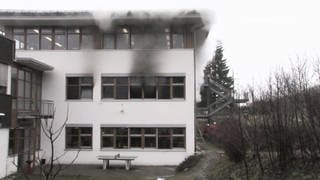 Haus bei dem aus den Fenstern Rauch austritt 