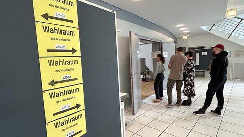 Menschen stehen vor den Wahlräumen bei der Wahl