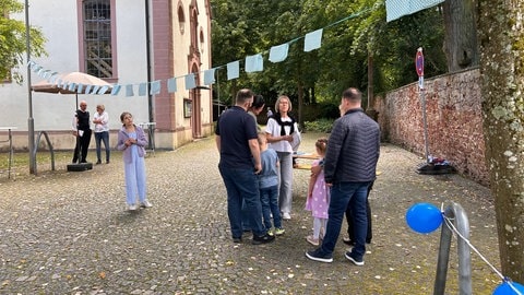 Menschen stehen vor einer Kirche