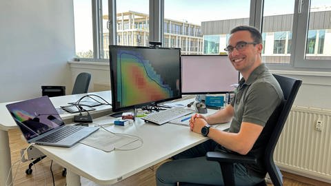Marius Bierdel, einer der Gründer der Firma constellr, sitzt vor seinem Computer. Auf dem Bildschirm ist ein Wärmebild zu sehen, wie es die Satelliten des Start-ups aufnehmen können.