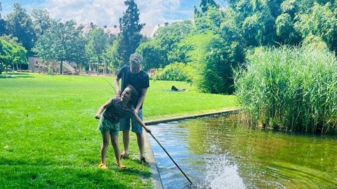 Malia und ihr Vater beim Entenfüttern und Spielen im Park