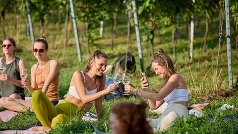 Zwei Frauen stoßen an und machen ein Handybild - bei Yoga und Wein kommt Lena Disch ins Schwärmen