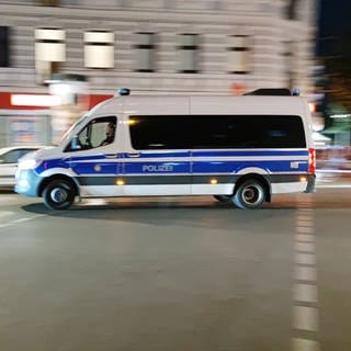 Ein Einsatzwagen der Berliner Polizei fährt nachts durch Neukölln. 