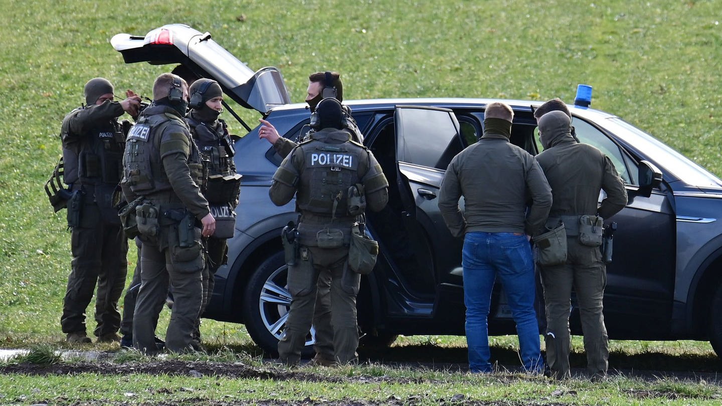 Mitglieder des SEK vor einem Einsatzfahrzeug besprechen das weitere Vorgehen in Unterkirnach.